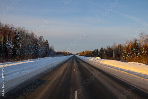 Winter track in the Siberian taiga. An icy winter highway runs through the snow and taiga. A section of the highway in the Khanty-Mansi Autonomous Okrug - Yugra between Khanty-Mansiysk and the city of