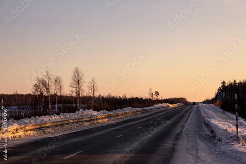 Winter track in the Siberian taiga. An icy winter highway runs through the snow and taiga. A section of the highway in the Khanty-Mansi Autonomous Okrug - Yugra between Khanty-Mansiysk and the city of