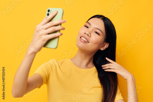 Portrait Asian beautiful young woman with a smartphone in hands fun emotions close-up Lifestyle unaltered