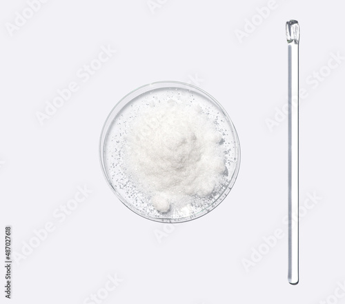 Closeup chemical ingredient on white laboratory table. Di-Ammonium Prosphate in Chemical Watch Glass placed next to stirring rod. Top View