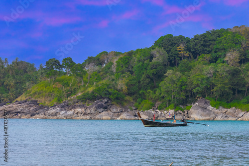 Long tail Boat on colourful sunset over a Beach in Phuket Thailand © Elias Bitar