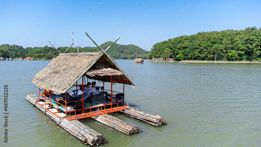 Couple in Area of Huai Krathing reservoir with bamboo raft shelter for Rafting and Eating. Beautiful natural landscape of the river and mountain with blue sky