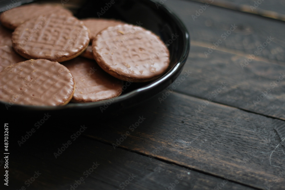 Chocolate flavored cookies Served in a black plate on a wooden table. Chocolate flavored cookies Served in a black plate on a wooden table.