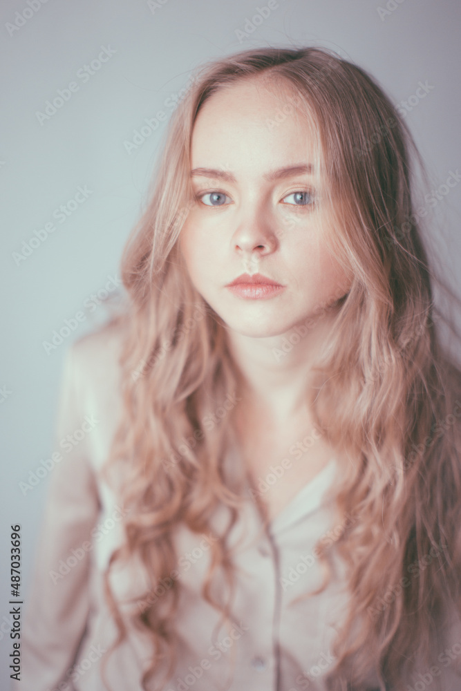 very gentle and heavenly portrait of a young girl with a doll-like appearance and white hair on a blue background. Light defocus and art noise on the frames very gentle and heavenly portrait of a young girl with a doll-like appearance and white hair on a blue background. Light defocus and art noise on the frames