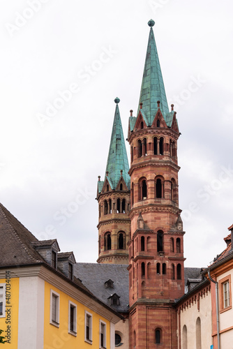 Brick colored towers with bronze green roofs at Würzburger Cathedral or Würzburger Dom between two apartment houses seen from the nave side