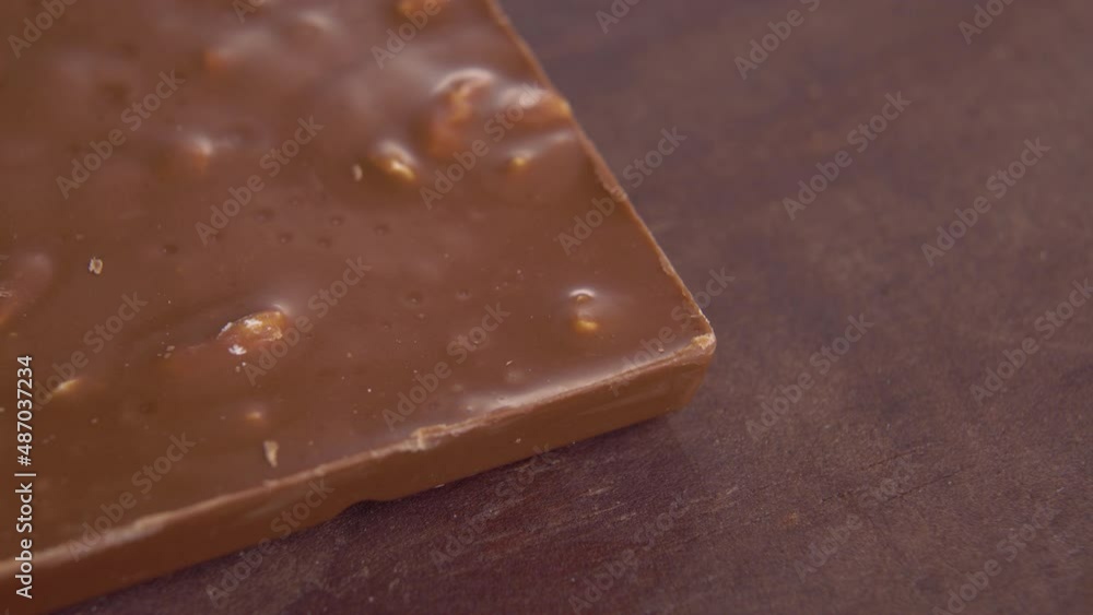 Milk chocolate texture with nuts on a wooden grungy surface. Macro. Rotation Milk chocolate texture with nuts on a wooden grungy surface. Macro. Rotation