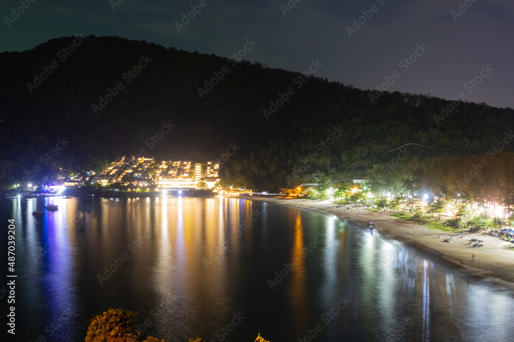 Colourful night lights after sunset over Naiharn Beach Phuket Thailand smooth waters and lights reflecting off the sea