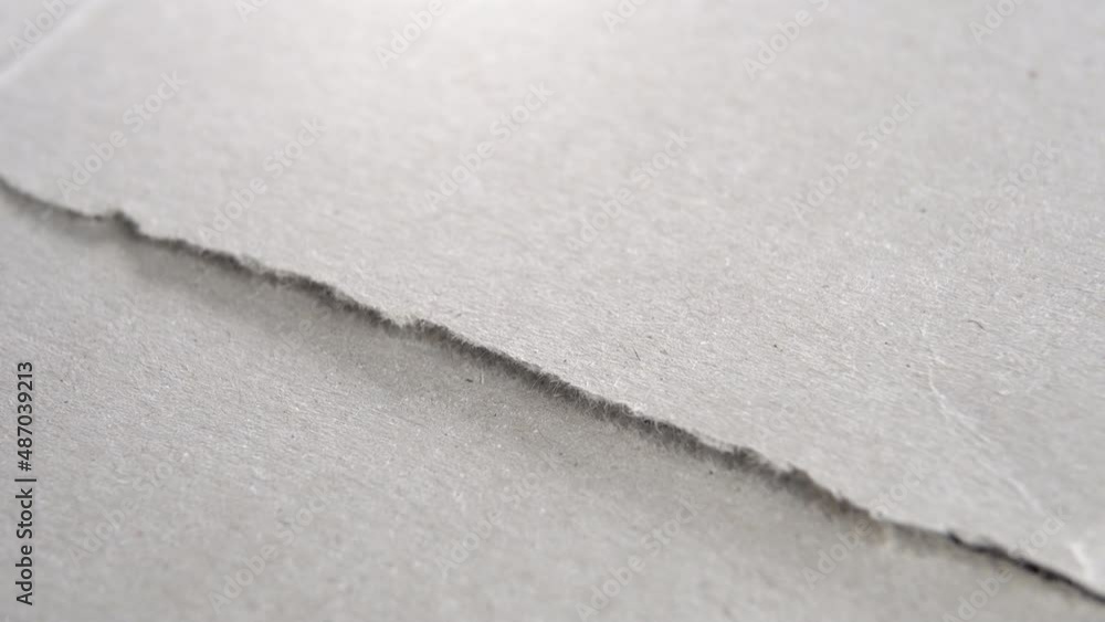 Torn grey paper edge. Ripped cardboard layers. Macro. Rotation. Abstract view. Grunge gray surface Torn grey paper edge. Ripped cardboard layers. Macro. Rotation. Abstract view. Grunge gray surface