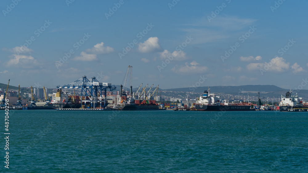 View of Novorossiysk Commercial Sea Port for loading container ships Diadema Nassau Supereco and Horizon. Turquoise water in foreground. Novorossiysk, Russia - September 15, 2021