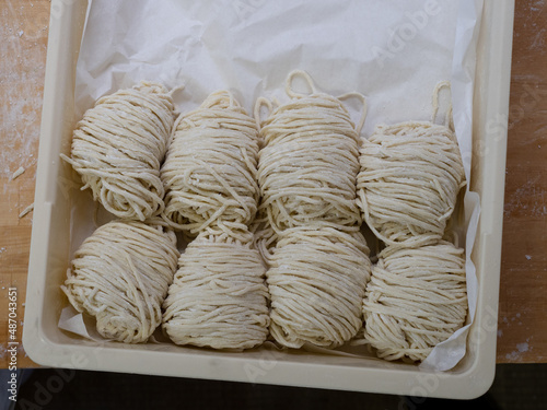 手打ちして丸めた後に箱に並べられたラーメンの麺