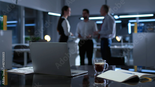 Blurred shot of business colleague talking late in office photo