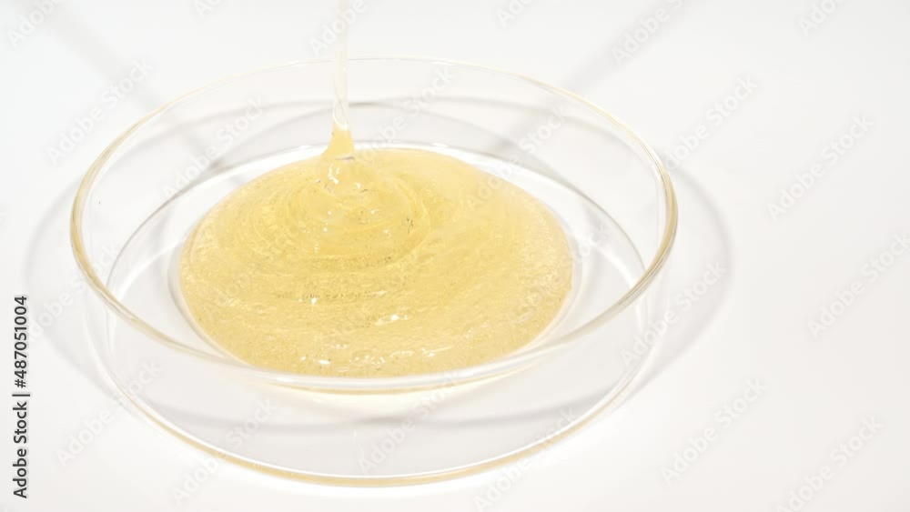 Transparent Cosmetic Gel Fluid dripping into the glass bowl of Petri. Macro Shot of Cosmetics serum, hyalurinic acid. Concept Skin care. High quality 4k footage Transparent Cosmetic Gel Fluid dripping into the glass bowl of Petri. Macro Shot of Cosmetics serum, hyalurinic acid. Concept Skin care. High quality 4k footage
