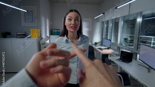 POV shot of businessman having argument with female colleague late in office.