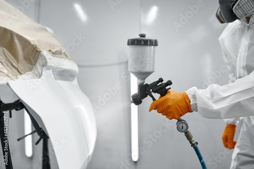 Obraz na plátne Technician in safety clothing spraying car paint