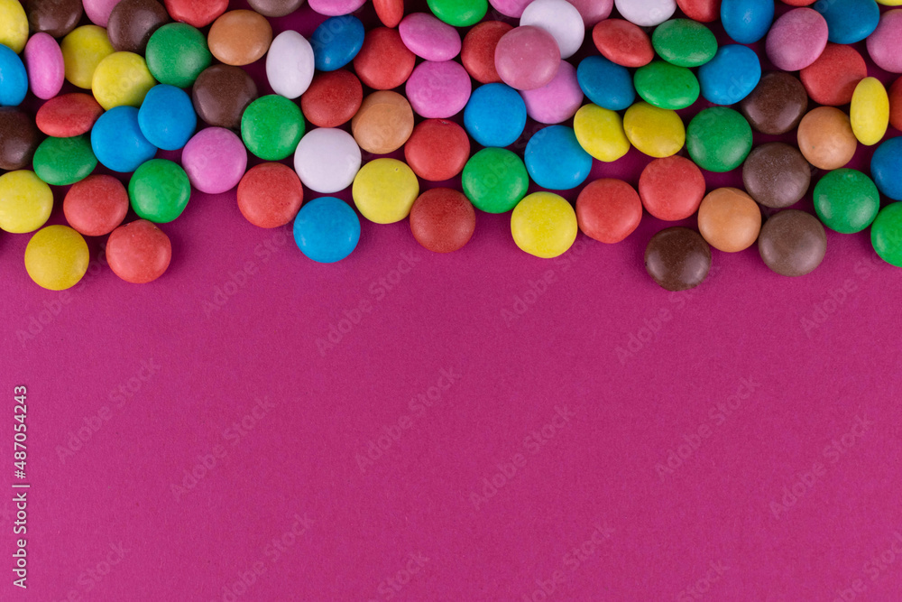 Multicolored candies on a pink background.Copy space. Multicolored candies on a pink background.Copy space.