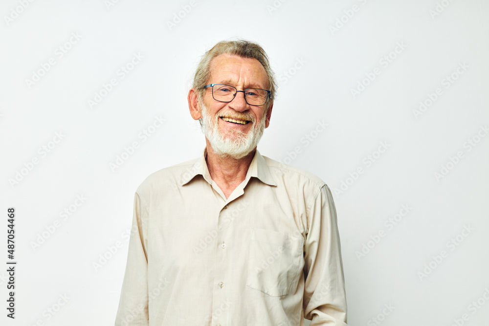 Elderly man posing in studio on gray background and smiling Elderly man posing in studio on gray background and smiling