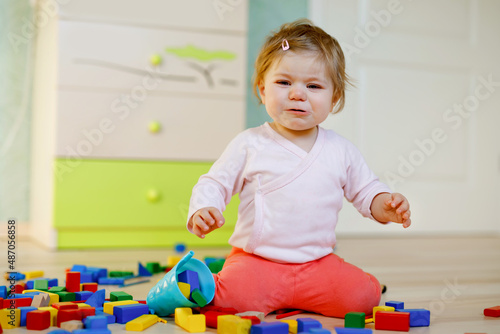 Fotografering Upset crying baby girl with educational toys