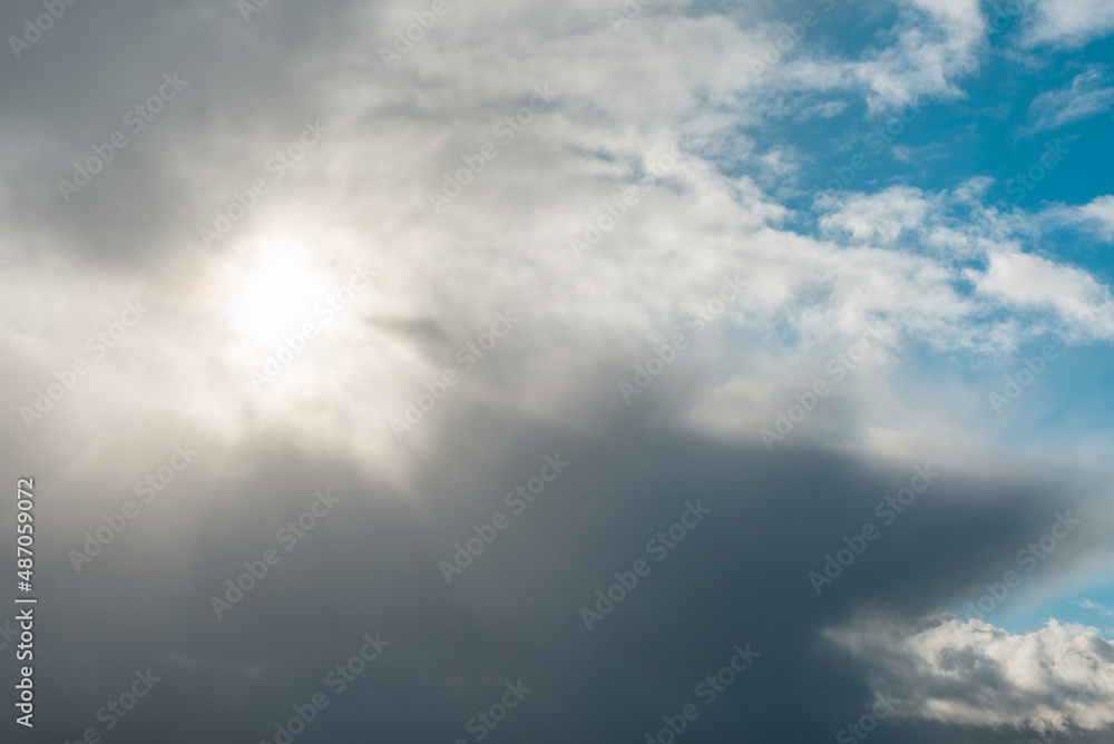 Dramatic sun illuminate through the clouds and shining on spring blue sky. Dramatic sun illuminate through the clouds and shining on spring blue sky.