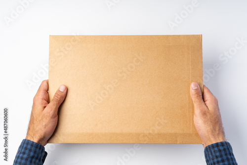 Male hand holding parcel post against white background © fotofabrika