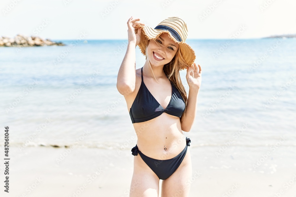 Young cuacasian girl smiling happy wearing bikini standing at the beach. Young cuacasian girl smiling happy wearing bikini standing at the beach.