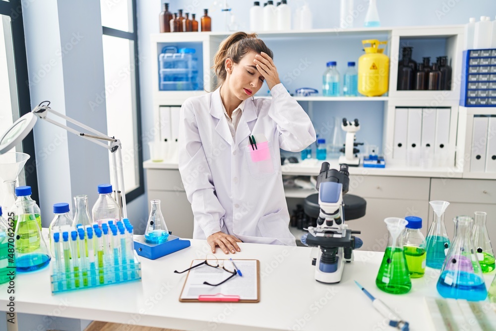 Young woman wearing scientist uniform stressed working at laboratory Young woman wearing scientist uniform stressed working at laboratory