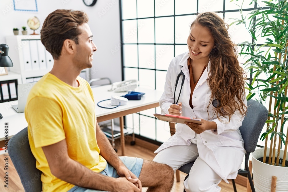 Man and woman having doctor visit speaking at clinic Man and woman having doctor visit speaking at clinic