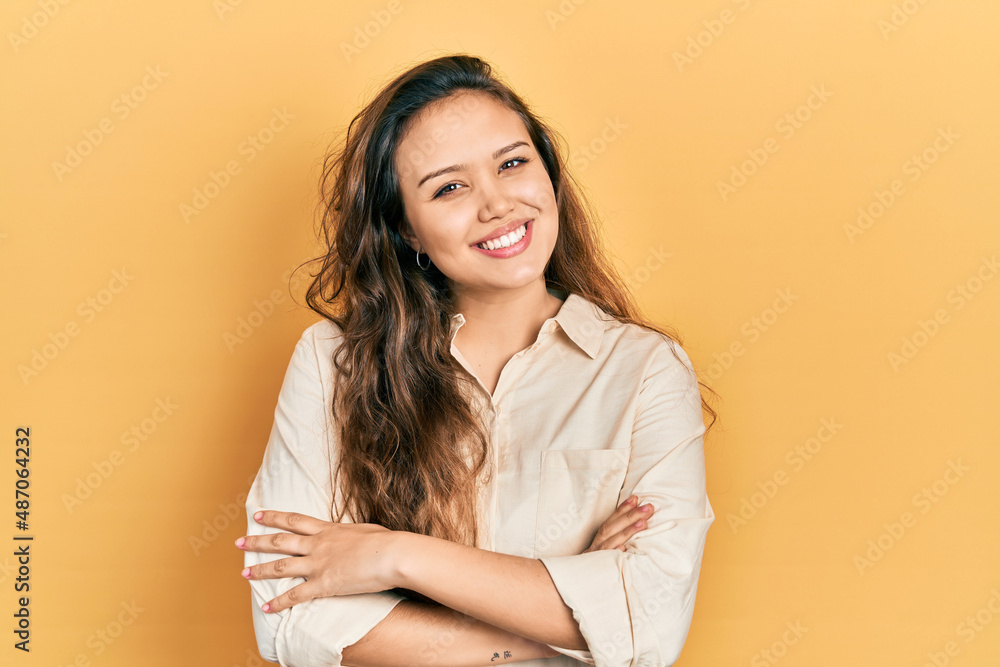 Young hispanic girl wearing casual clothes happy face smiling with crossed arms looking at the camera. positive person. Young hispanic girl wearing casual clothes happy face smiling with crossed arms looking at the camera. positive person.
