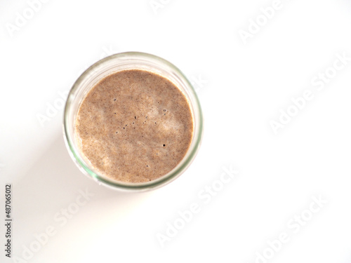 Homemade bread sourdough in a glass jar isolated on white background.
