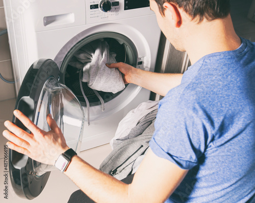 Tableau sur toile Man loading the washer dryer with clothes
