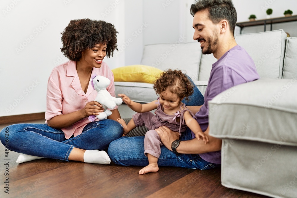 Couple and daughter smiling confident playing with toys sitting on the floor at home