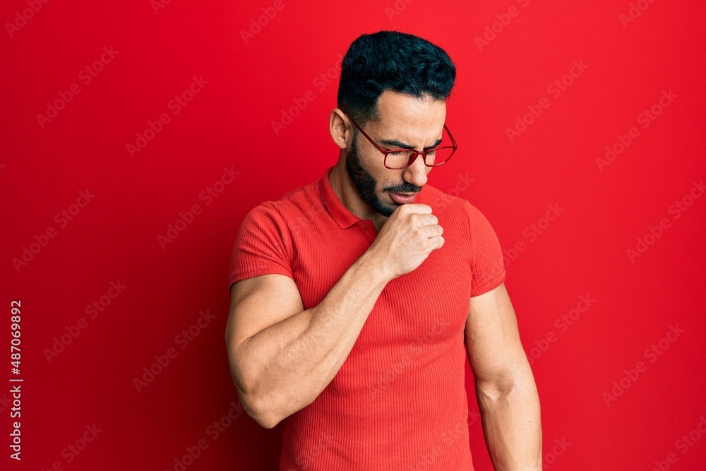 Young hispanic man wearing casual clothes and glasses feeling unwell and coughing as symptom for cold or bronchitis. health care concept.