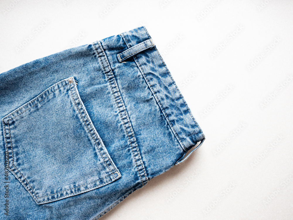 Blue jeans close-up on a white background. Belt and jeans pockets Blue jeans close-up on a white background. Belt and jeans pockets