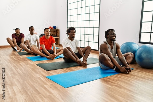 Group of young african american man stretching at sport center.