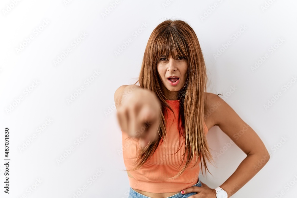 Fototapeta premium Hispanic woman with bang hairstyle standing over isolated background pointing displeased and frustrated to the camera, angry and furious with you