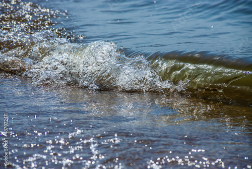 Sea wave with spray and foam near the shore