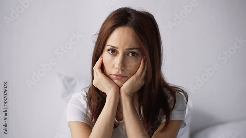 offended woman with hands near face looking at camera at home