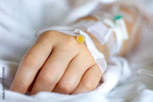 Woman's hand piercing needle to give saline solution
