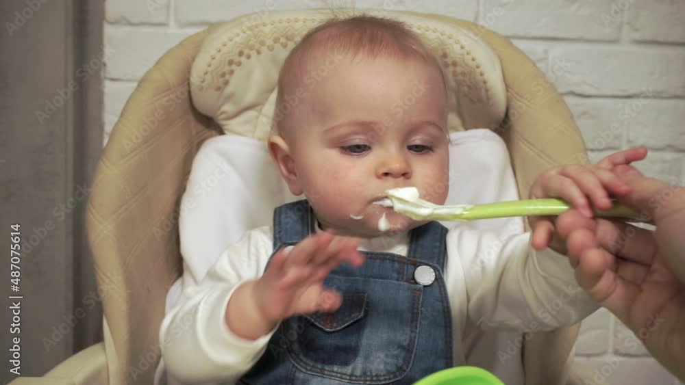 father's hand feeding baby from spoon father's hand feeding baby from spoon