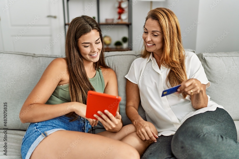 Mother and daughter smiling confident using touchpad and credit card at home Mother and daughter smiling confident using touchpad and credit card at home