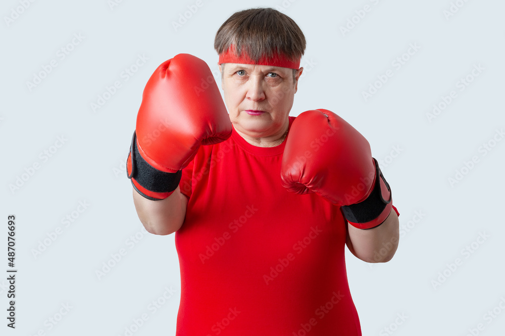 Elderly woman boxer in red on a white background. Elderly woman boxer in red on a white background.