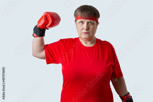 Elderly woman boxer in red on a white background.