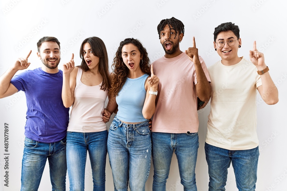 Group of young people standing together over isolated background pointing finger up with successful idea. exited and happy. number one. Group of young people standing together over isolated background pointing finger up with successful idea. exited and happy. number one.