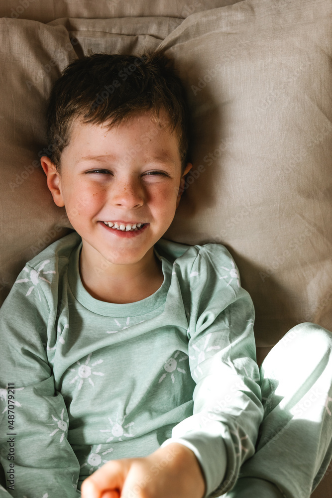 Cheerful boy lying down on bed Cheerful boy lying down on bed