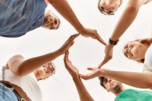 Group of young friends doing circle symbol with hands together