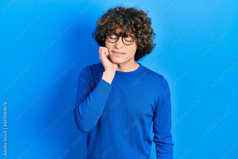 Handsome young man wearing casual clothes and glasses touching mouth with hand with painful expression because of toothache or dental illness on teeth. dentist Handsome young man wearing casual clothes and glasses touching mouth with hand with painful expression because of toothache or dental illness on teeth. dentist