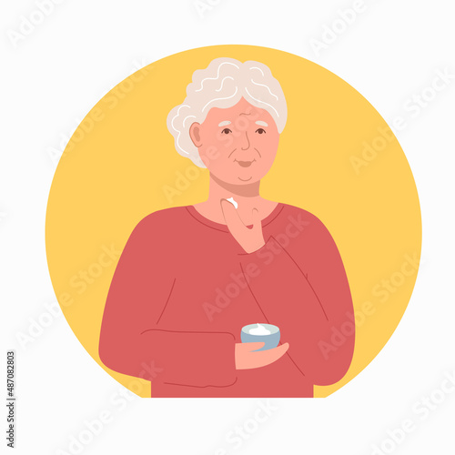 An elderly woman applies a face cream