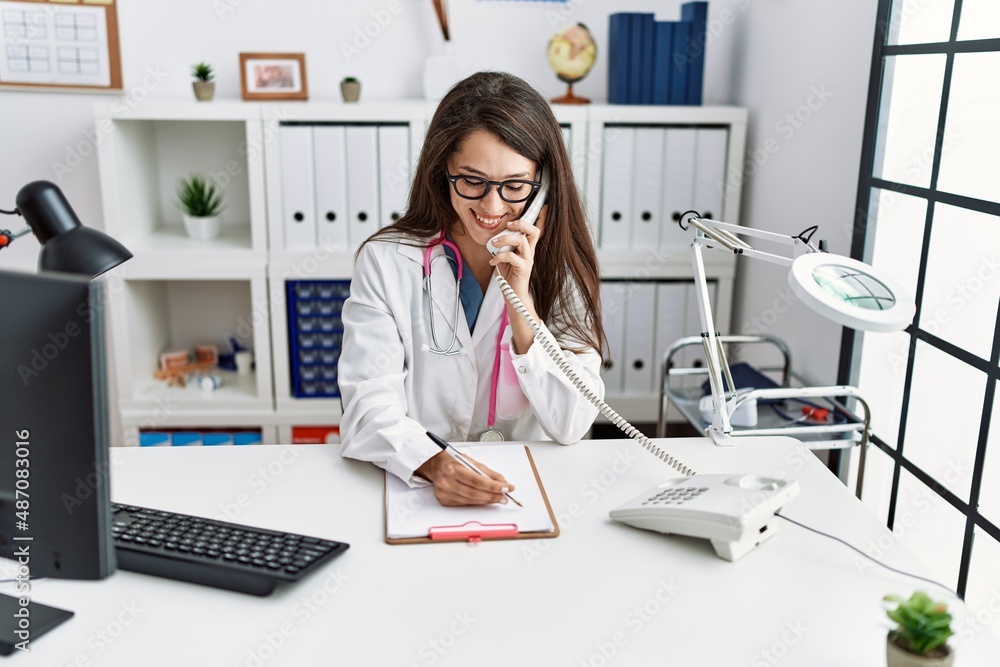 Young hispanic woman wearing doctor uniform working at clinic Young hispanic woman wearing doctor uniform working at clinic