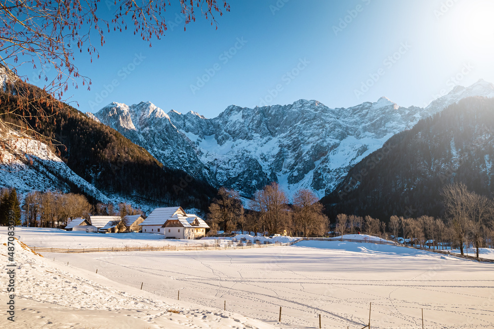 Beautiful scene of a village in a mountain valley on a bright sunny winter day. Clear snow shining and sparkling under the sunbeams.