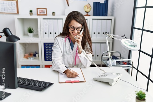 Young hispanic woman wearing doctor uniform working at clinic © Krakenimages.com