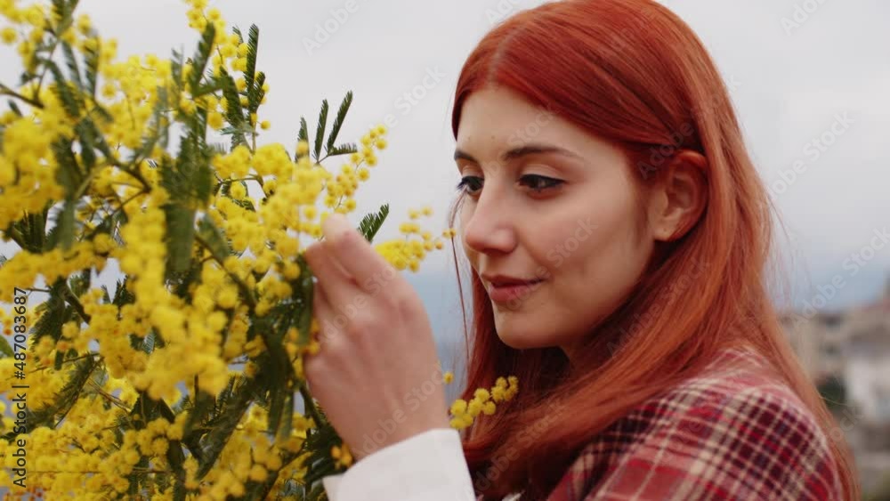 Young girl celebrates women's day with yellow mimosa flowers in hand Young girl celebrates women's day with yellow mimosa flowers in hand